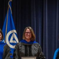 Provost Mili looks proud as she smiles at 2 women faculty